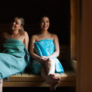 Twee dames in blauwe hammamdoek genieten in de Stuga sauna.
